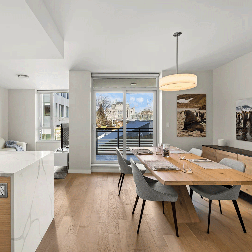 Spacious dining area with modern furniture and large windows displaying urban views in Victoria
