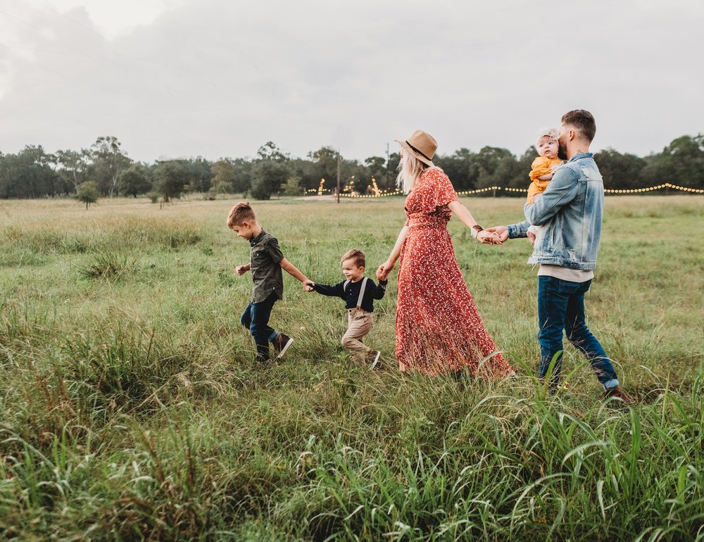 Family enjoying a walk in the countryside at dusk, creating memories together in nature